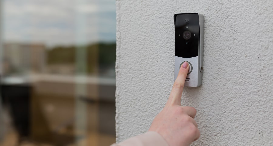 Person pressing button of smart doorbell camera